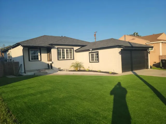 Same home after a full exterior remodel, with new siding, roofing, garage door, and landscaping
