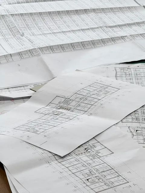Architectural blueprints and floor plans spread out on a table