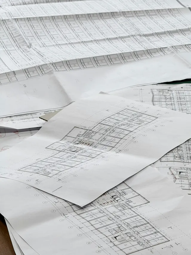 Architectural blueprints and floor plans spread out on a table