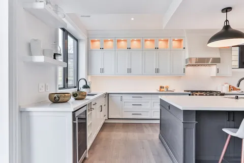 Transitional kitchen with white cabinets and a navy island